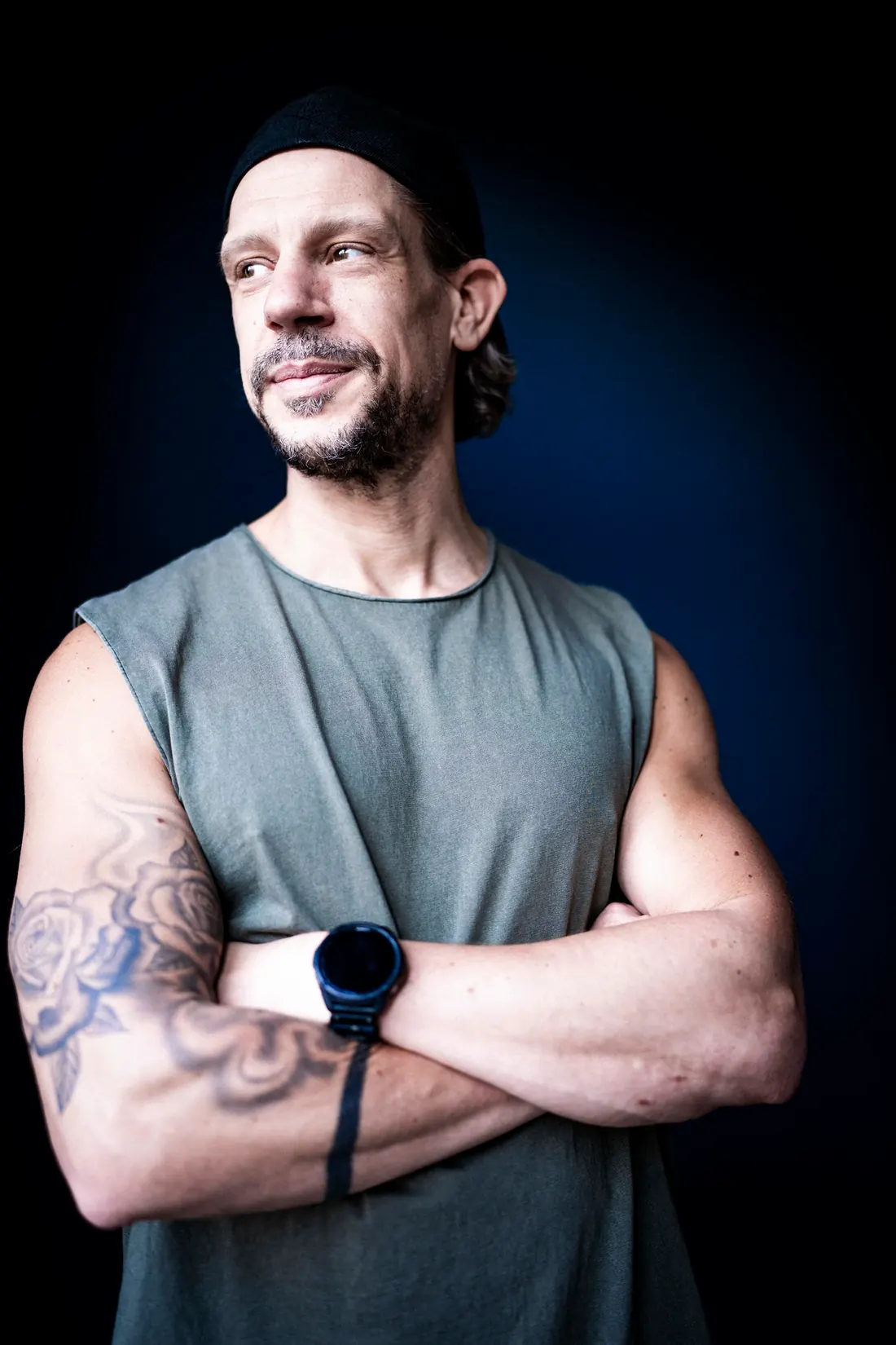 Alex with folded arms in front of a blue wall