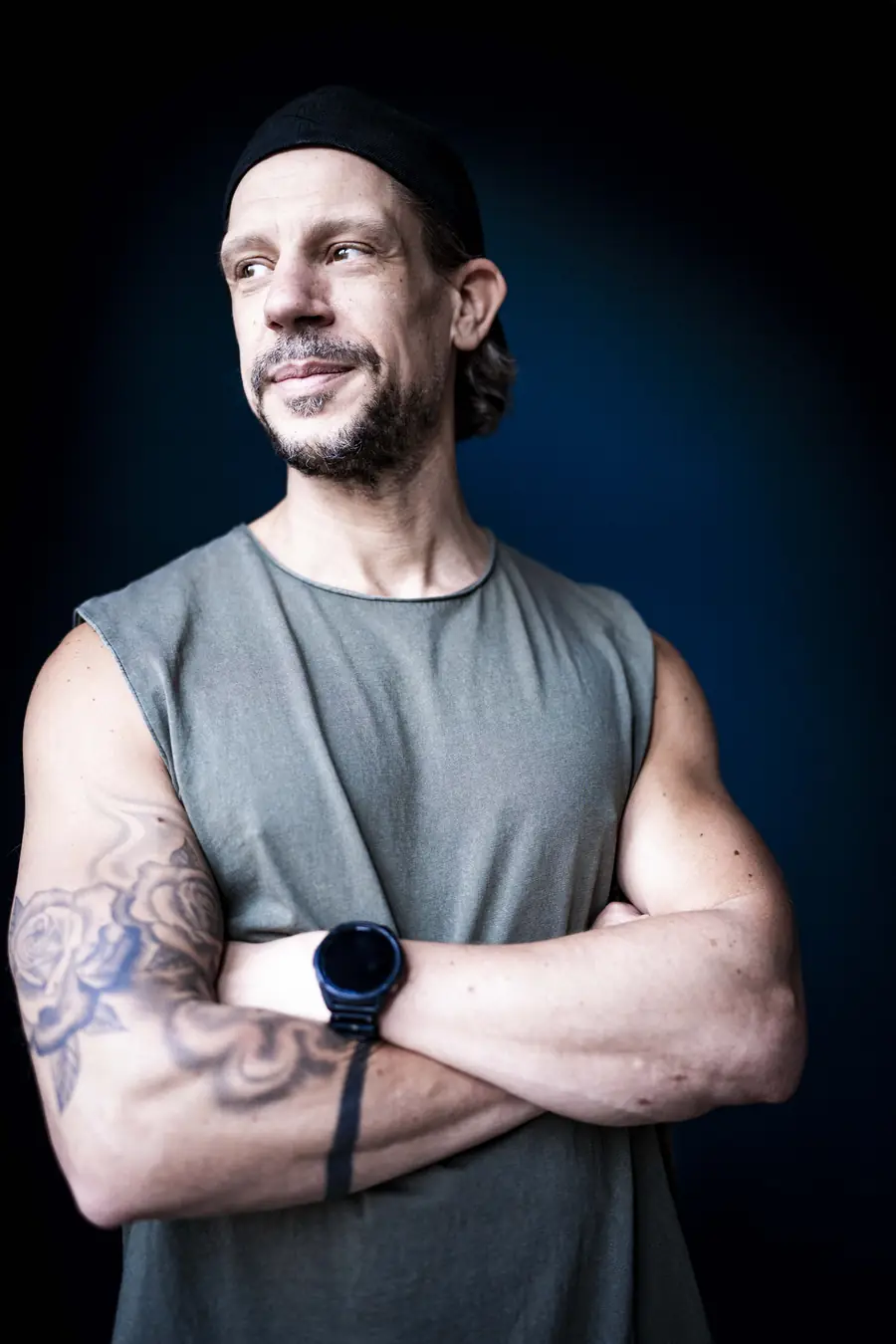 Alex with folded arms in front of a blue wall